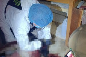 Un investigador forense con traje de protección trabaja en la escena del presunto feminicidio