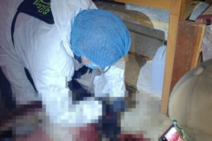 Un investigador forense con traje de protección trabaja en la escena del presunto feminicidio