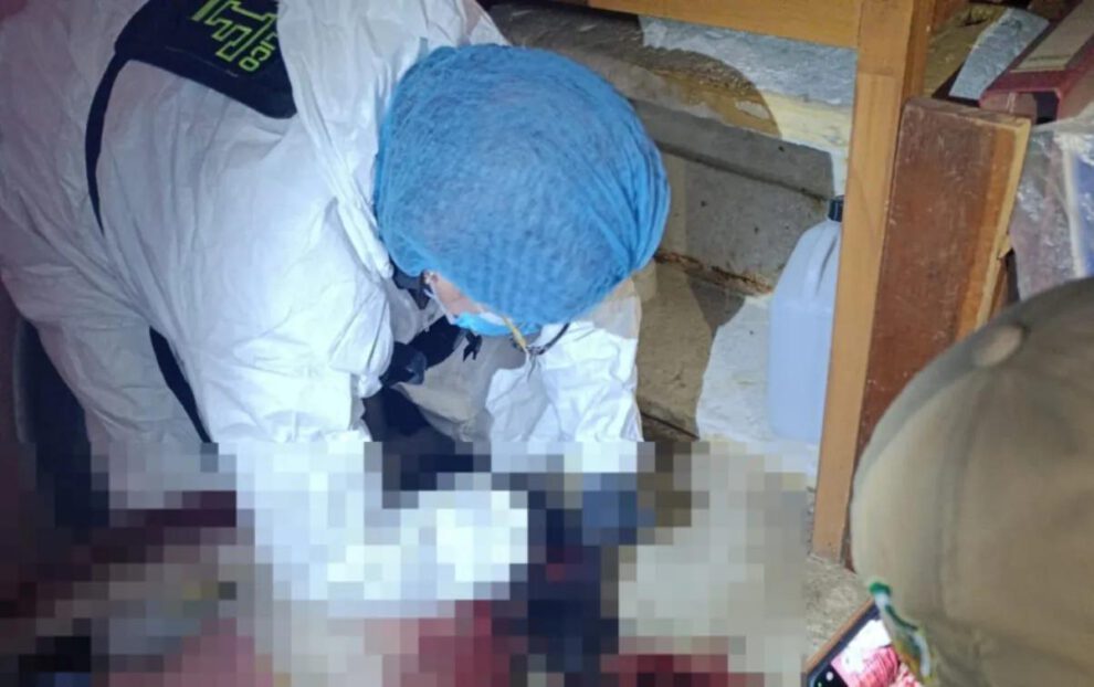 Un investigador forense con traje de protección trabaja en la escena del presunto feminicidio