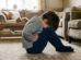 Niño sentado en el suelo de una sala