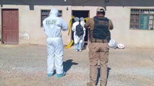 Personal policial y forense con trajes de bioseguridad realizando una intervención