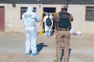 Personal policial y forense con trajes de bioseguridad realizando una intervención