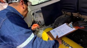 Una persona inspeccionando un vehículo