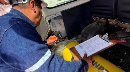 Una persona inspeccionando un vehículo