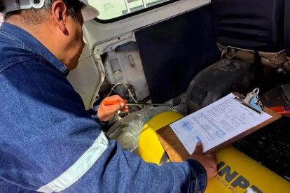 Una persona inspeccionando un vehículo