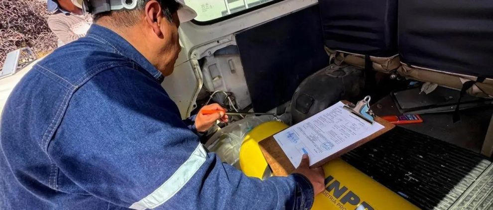 Una persona inspeccionando un vehículo