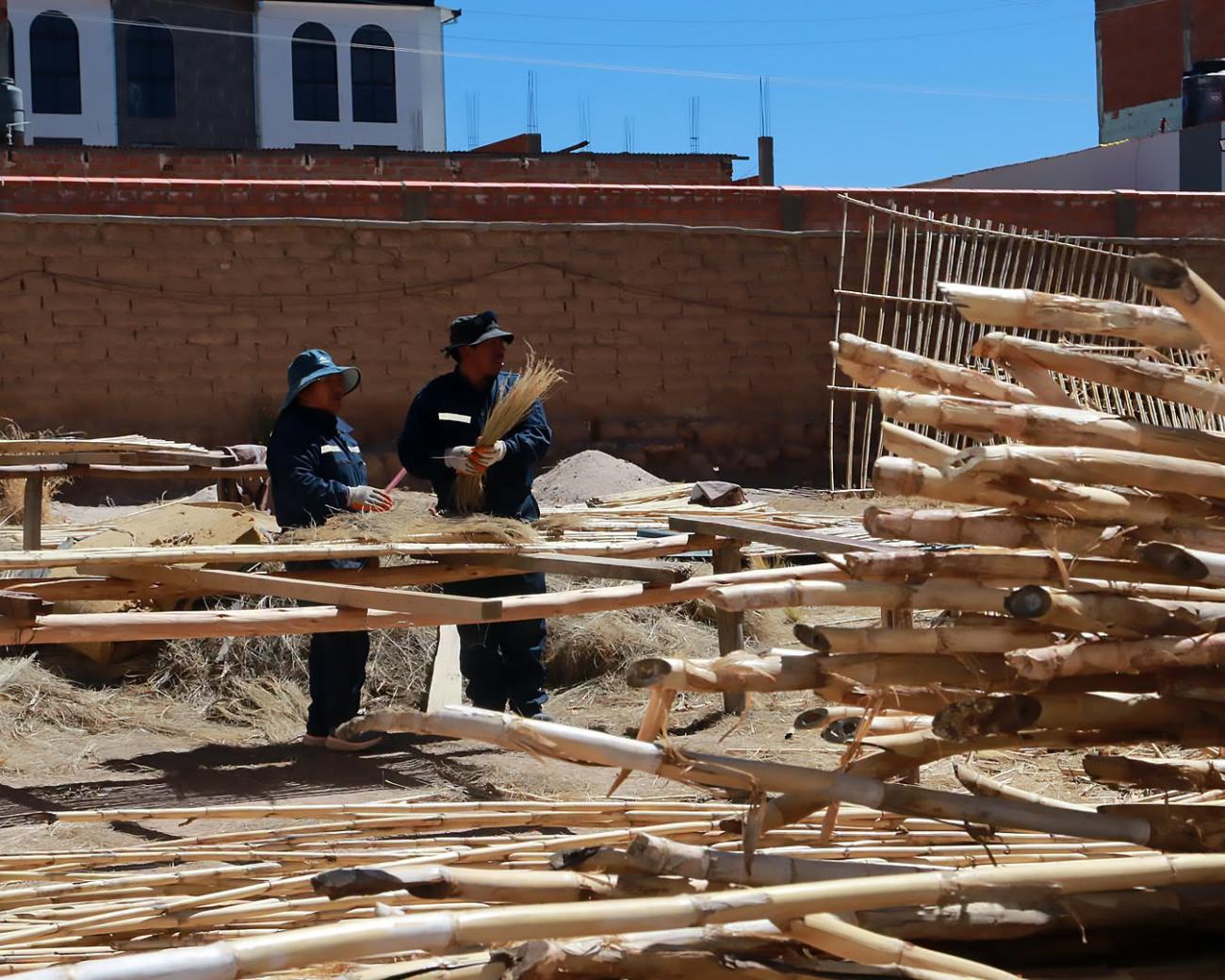 Trabajadores alistando materiales tradicionales para la renovación de la cubierta
