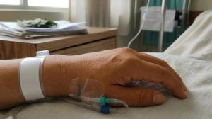 una mano en la camilla de un hospital
