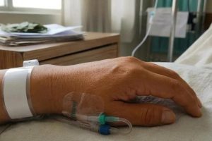 una mano en la camilla de un hospital