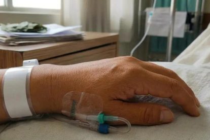 una mano en la camilla de un hospital