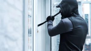 Un ladrón intentando entrar a una casa