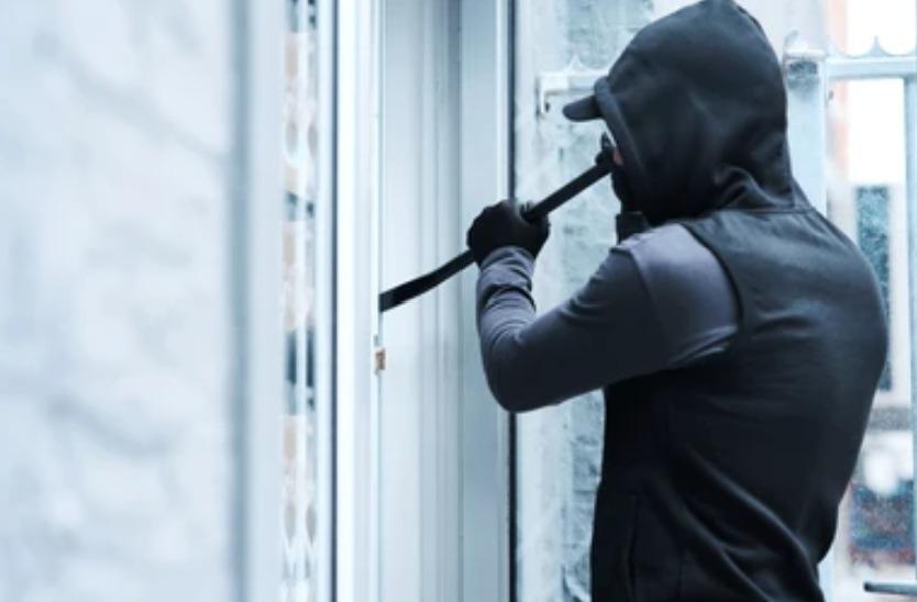 Un ladrón intentando entrar a una casa