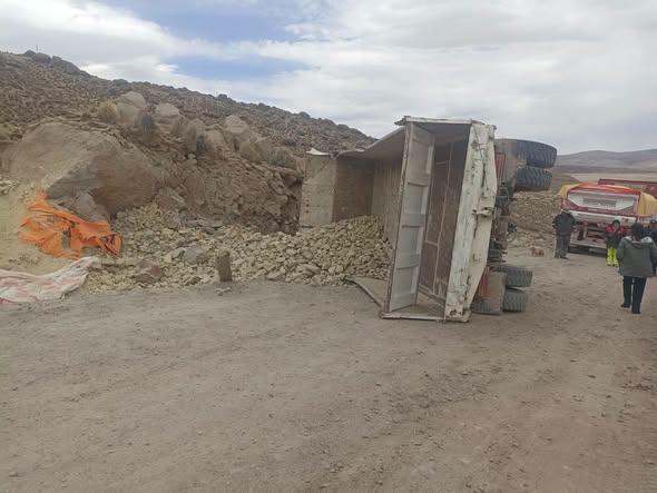Camión volqueta volcado en un camino