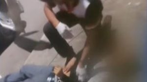 Un señor revisando a otra persona tendida en el suelo