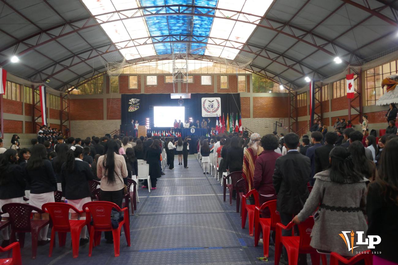 Panorama del coliseo institucional repleto de estudiantes, docentes y padres de familia