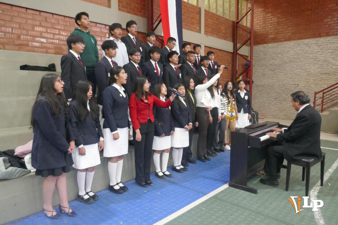 Presentación del coro estudiantil con acompañamiento musical durante la inauguración
