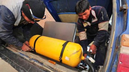 Dos personas con un silindro de gas