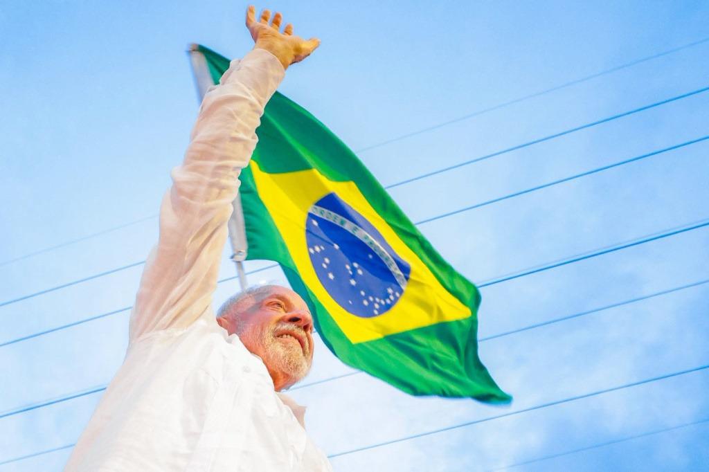 Silva levanta el brazo en señal de victoria frente a la bandera de Brasil
