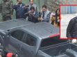 Un grupo de periodistas filamando un vehículo negro .
