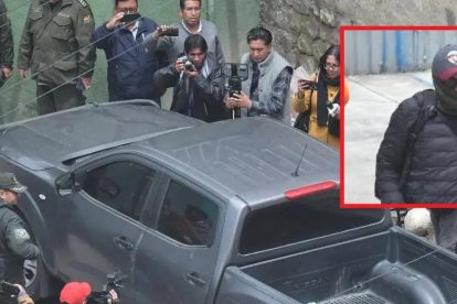 Un grupo de periodistas filamando un vehículo negro .