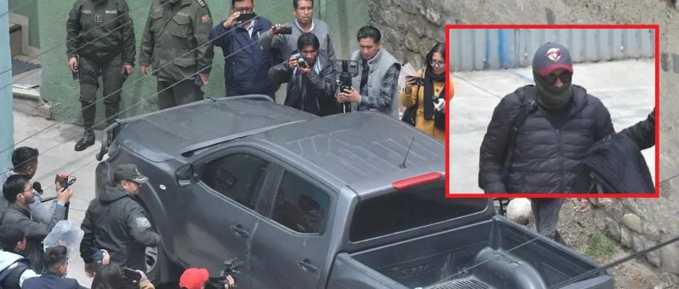 Un grupo de periodistas filamando un vehículo negro .