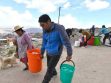 personas con baldes y tachos de agua
