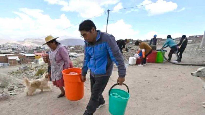 personas con baldes y tachos de agua