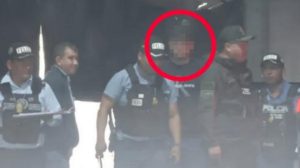 Un grupo de policias y un joven aprehendido