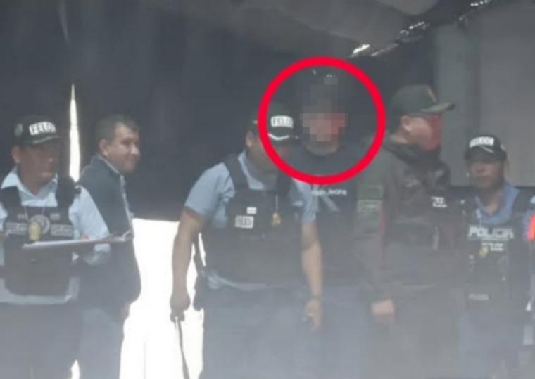 Un grupo de policias y un joven aprehendido